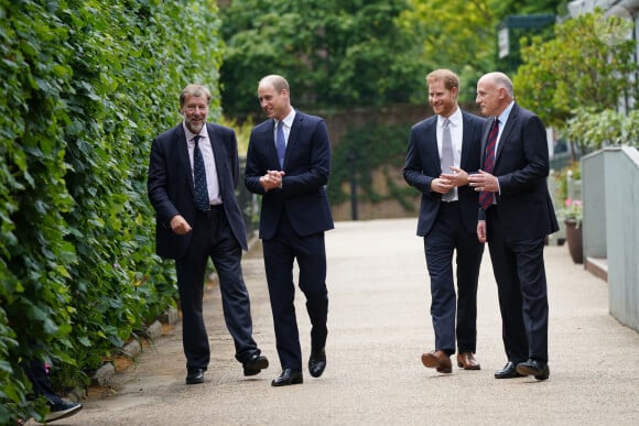 Le prince William, duc de Cambridge, et son frère Le prince Harry, duc de Sussex, aux côtés de Rupert Gavinà (gauche) et Jamie Lowther-Pinkerton (droite) dans les jardins de Kensington Palace à Londres, le 1er juillet 2021.
