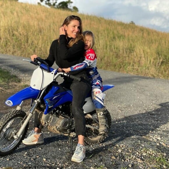 Elsa Pataky et son fils font de la moto cross à la campagne.