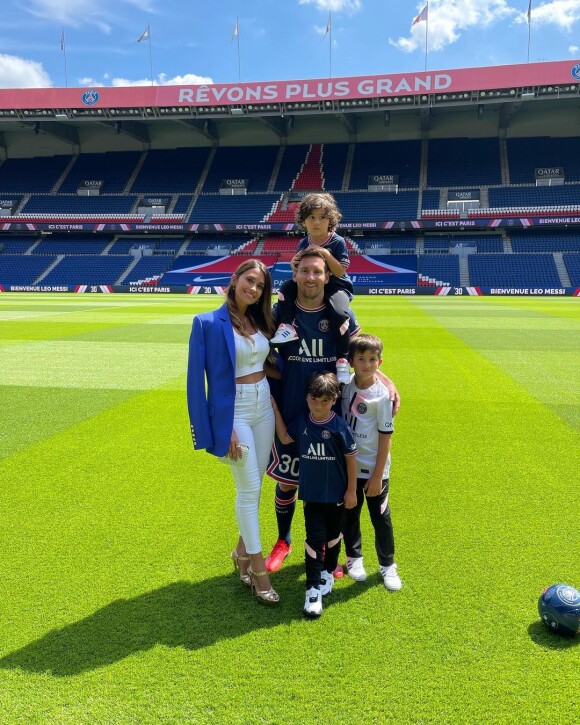 Lionel Messi entourée de sa femme Antonela et de leurs trois fils qui portent les maillots du PSG. Photo prise sur la pelouse du Parc des princes le 11 août 2021.