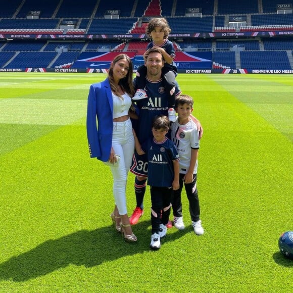 Lionel Messi entourée de sa femme Antonela et de leurs trois fils qui portent les maillots du PSG. Photo prise sur la pelouse du Parc des princes le 11 août 2021.