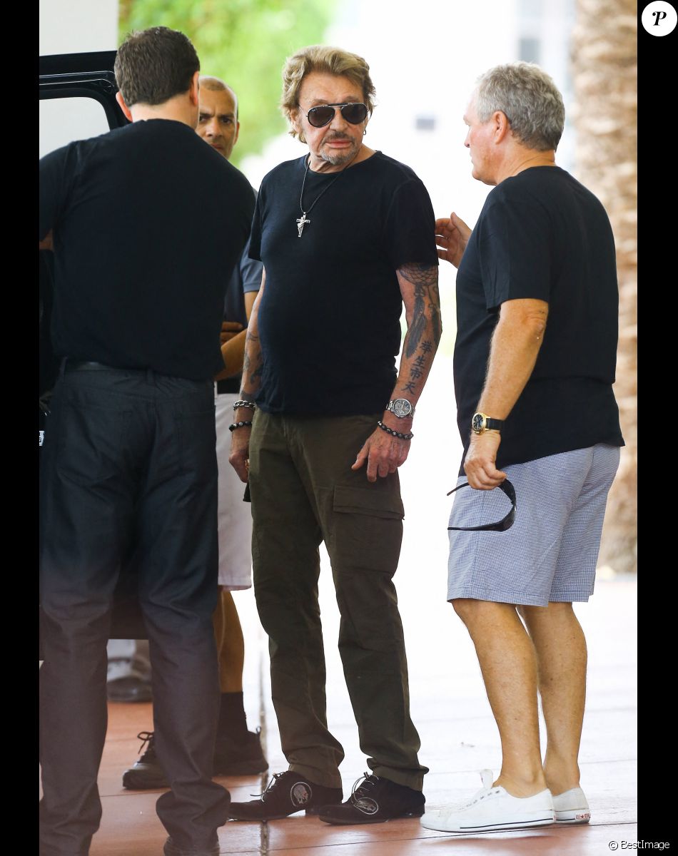 Johnny Hallyday et sa femme Laeticia quittent leur hôtel en compagnie de Sébastien Farran et du père de Laeticia, André Boudou à Miami, le 12 mai 2014.