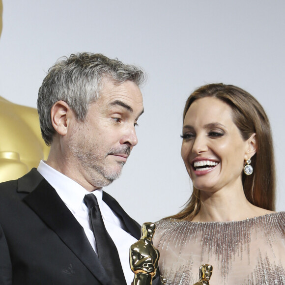 Alfonso Cuarón (Oscar du meilleur réalisateur pour le film "Gravity") et Angelina Jolie (habillée en Elie Saab) - Pressroom - 86ème cérémonie des Oscars à Hollywood, le 2 mars 2014.