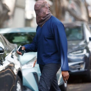 Exclusif - Kanye West se protège de la canicule en portant une cagoule sur la tête dans la rue à Los Angeles le 15 juin 2021.