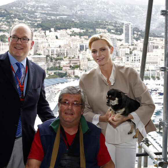 Le prince Albert II et la princesse Charlène de Monaco, avec son chien Monté, ont rendu visite aux spectateurs de la tribune de l'association monégasque des handicapés moteur, lors des essais du Grand Prix de Monaco. Le 23 mai 2015.