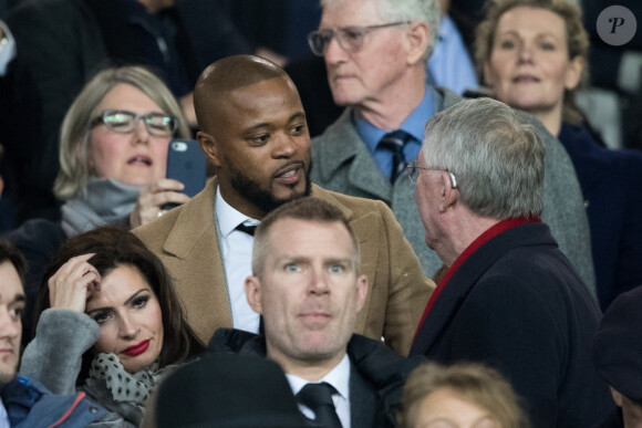 Patrice Evra et Sir Alex Ferguson dans les tribunes du stade Old Trafford lors du match de 8ème de finale aller de Ligue des champions opposant le Paris Saint-Germain à Manchester Unted à Manchester, Royaume Uni, le 12 février 2019. PSG a gagné 2-0.