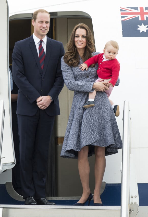 Le prince William, Catherine Kate Middleton la duchesse de Cambridge et leur fils George montent à bord d'un avion pour rentrer à Londres après leur visite officielle en Australie, le 25 avril 2014.