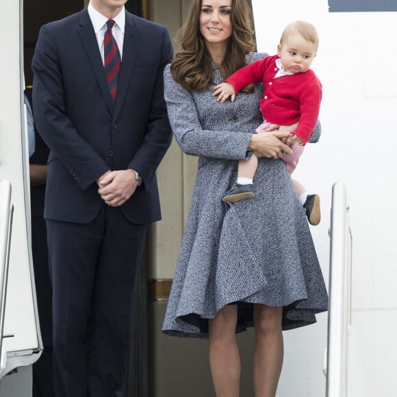 Le prince William, Catherine Kate Middleton la duchesse de Cambridge et leur fils George montent à bord d'un avion pour rentrer à Londres après leur visite officielle en Australie, le 25 avril 2014.