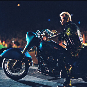 Johnny Hallyday arrivant en Harley Davidson à un concert au Stade de France en 1998.