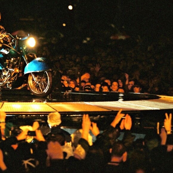 Johnny Hallyday sur scène au Stade de France avec sa moto "Laura Eyes", le 11 septembre 1998.