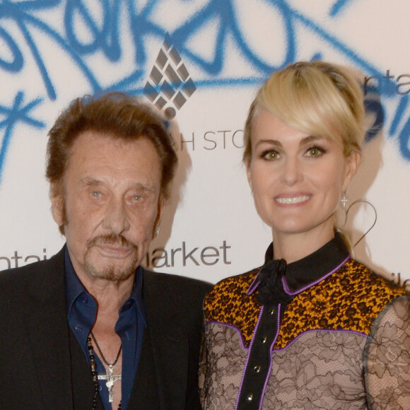 Exclusif - Johnny Hallyday et sa femme Laeticia Hallyday - Le joaillier Aaron Jah Stone et l'artiste Kongo ont présenté une nouvelle collection qui allie Street Art et Joaillerie chez Montaigne Market à Paris le 4 mars 2016. L'artiste Kongo a réalisé une performance en live. L'oeuvre a été offerte à l'Association La bonne étoile présidée par Laeticia Hallyday. 