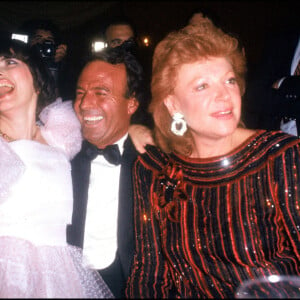 Archives - Julio Iglesias entouré de Mireille Mathieu et de la chanteuse Régine lors d'une soirée à Paris en 1983.