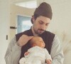 Coeur de Pirate a partagé cette photo de son compagnon tenant son bébé dans les bras, sur Instagram. Février 2022.