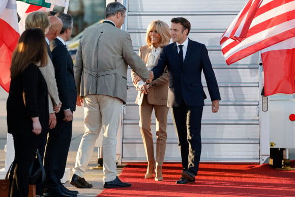 Le président français Emmanuel Macron et sa femme Brigitte Macron sont accueillis par le Premier ministre bavarois Markus Soeder à leur arrivée à l'aéroport Franz Josef Strauss de Munich, dans le sud de l'Allemagne, le 25 juin 2022, à la veille du sommet du G7