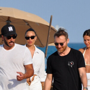 David Guetta et sa compagne Jessica Ledon, avec son ami le DJ Cédric Gervais et sa fiancée Adriana Gutierrez, se prélassent sur la plage du palace Setai à Miami, le 20 mars 2022. 