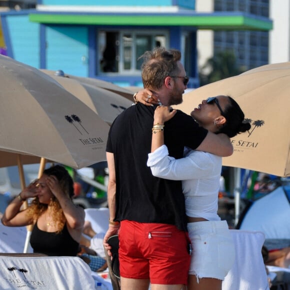 David Guetta et sa compagne Jessica Ledon, avec son ami le DJ Cédric Gervais et sa fiancée Adriana Gutierrez, se prélassent sur la plage du palace Setai à Miami, le 20 mars 2022. 