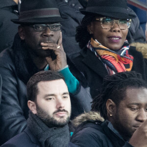 Lilian Thuram et sa compagne Kareen Guiock, Raymond Domenech dans les tribunes lors du 16ème de finale de la Coupe de France 2018 "PSG - Guingamp (4-2)" au Parc des Princes à Paris, le 24 janvier 2018.