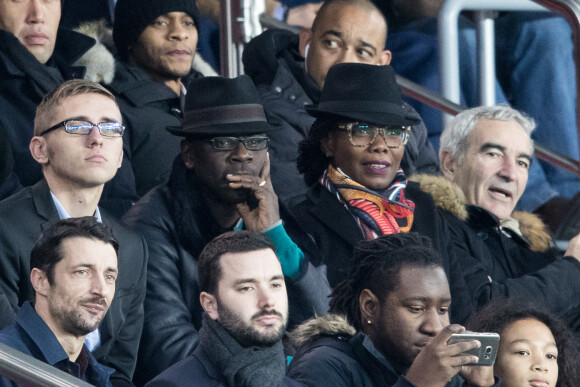 Lilian Thuram et sa compagne Kareen Guiock, Raymond Domenech dans les tribunes lors du 16ème de finale de la Coupe de France 2018 "PSG - Guingamp (4-2)" au Parc des Princes à Paris, le 24 janvier 2018.