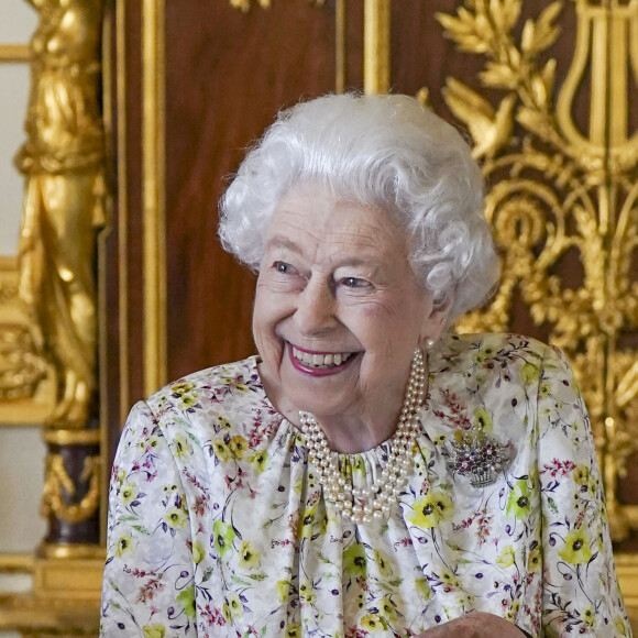 La reine Elisabeth II d'Angleterre parcourt l'exposition d'objets de la société d'artisanat britannique Halcyon Days, pour marquer son jubilé de platine, au château de Windsor, le 23 mars 2022. 