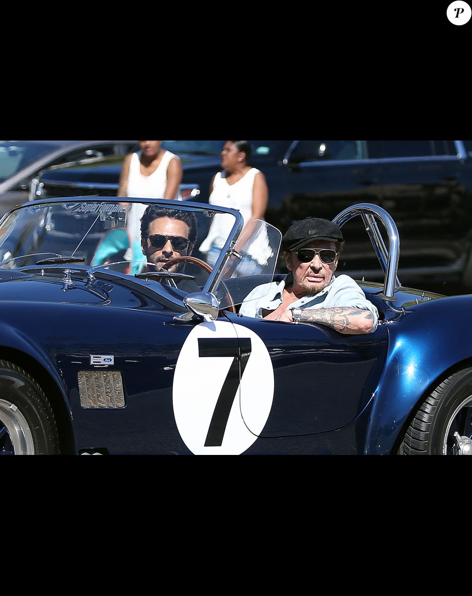 Johnny Hallyday accompagné de Maxim Nucci (Yodelice), arrive au restaurant "Soho House" à Malibu, au volant de son cabriolet AC Cobra marqué de son chiffre porte-bonheur, le numéro 7. Laeticia Hallyday, toujours en béquilles, les rejoint dans une autre voiture. Malibu, le 09 mars 2017.