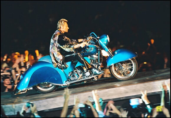 Info du 19 mars 2022 - La mythique Harley-Davidson "Laura Eyes", modèle Softail Heritage 1340, de Johnny Hallyday s'est vendue aux enchères vendredi soir (18 mars 2022) au salon Retromobile de Paris pour la somme de 470.840 euros, un record pour une moto de la marque datant d'après-guerre, selon la maison Artcurial qui aorchestré la vente. La moto avait été estimée entre 50.000 et 250.000 euros, mais elle a fait l'objet d'une bataille de dix minutes entre enchérisseurs avant d'être adjugée 470.840 euros à un acquéreur anonyme. L'Harley avait été offerte à la star par le patron d'Universal Music Pascal Nègre, et renommée "Laura Eyes" en hommage à la fille de Johnny Laura Smet, Le chanteur l'a conduit lors d'un "road trip" aux Etats-Unis en 1990.