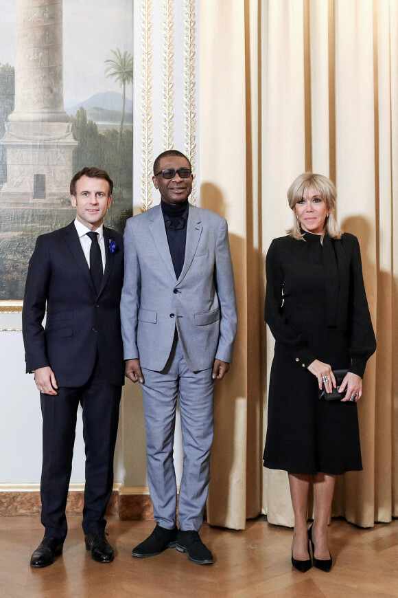 Le président de la République française, Emmanuel Macron accompagné de sa femme la Première dame, Brigitte Macron reçoit Youssou N'Dour pour un dîner du Forum de Paris sur la paix, au palais de l'Elysée, à Paris