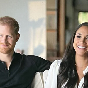 Images du documentaire Netflix "Harry & Meghan".  The Sussexes’ bombshell Netflix documentary gives inside look at home footage of son Archie being introduced to ‘grandma’ Princess Diana while Meghan is shown crying. The series contains tears from Meghan, who Harry repeatedly compares to Princess Diana claiming that both his mother and wife were being hunted by the press. In episode one, the Duke and Duchess of Sussex begin by filming themselves on the day they ended their royal duties in March 2020, with Harry in the VIP lounge at Heathrow as he flew to Canada. Meghan cries with a towel on her head as she declares: “I don't even know where to begin.” – in self filmed footage tht was shot captured six months before their 0million deal with Netflix was signed in September 2020. The privacy-conscious couple have given extraordinary access to the streaming giant, including a treasure trove of pictures and footage from their private lives including of their children. There are scenes of both Harry and Megahn playing with Archie, who is also seen being shown a photo of Princess Diana. The toddler reaches out and touches the photo as Meghan can be heard referring to Diana as ‘grandma’. There’s more footage of the couple out of a walk, with Archie running ahead as Harry pushes a pram with daughter Lillibet in it. Other scenes show Meghan holding Archie while feeding chickens and Harry pushing him around on a suitcase. The couple are also seen sitting together on a sofa and talking about why they wanted to film the documentary as well as branding their engagement announcement in 2017 an 'orchestrated reality show'. 
