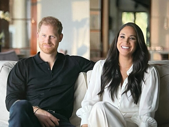 Images du documentaire Netflix "Harry & Meghan".  The Sussexes’ bombshell Netflix documentary gives inside look at home footage of son Archie being introduced to ‘grandma’ Princess Diana while Meghan is shown crying. The series contains tears from Meghan, who Harry repeatedly compares to Princess Diana claiming that both his mother and wife were being hunted by the press. In episode one, the Duke and Duchess of Sussex begin by filming themselves on the day they ended their royal duties in March 2020, with Harry in the VIP lounge at Heathrow as he flew to Canada. Meghan cries with a towel on her head as she declares: “I don't even know where to begin.” – in self filmed footage tht was shot captured six months before their 0million deal with Netflix was signed in September 2020. The privacy-conscious couple have given extraordinary access to the streaming giant, including a treasure trove of pictures and footage from their private lives including of their children. There are scenes of both Harry and Megahn playing with Archie, who is also seen being shown a photo of Princess Diana. The toddler reaches out and touches the photo as Meghan can be heard referring to Diana as ‘grandma’. There’s more footage of the couple out of a walk, with Archie running ahead as Harry pushes a pram with daughter Lillibet in it. Other scenes show Meghan holding Archie while feeding chickens and Harry pushing him around on a suitcase. The couple are also seen sitting together on a sofa and talking about why they wanted to film the documentary as well as branding their engagement announcement in 2017 an 'orchestrated reality show'. 