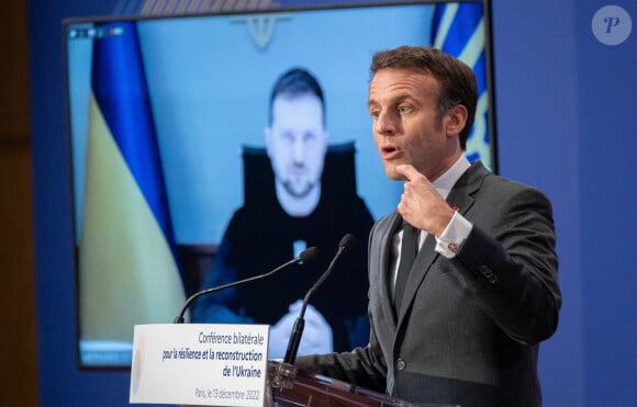 Le président français Emmanuel Macron prononce un discours pendant que le président ukrainien Volodymyr Zelensky écoute par liaison vidéo lors de la conférence bilatérale pour la résilience et la reconstruction de l'Ukraine au ministère de l'Économie à Paris, FRance, le 13 décembre 2022. © Jacques Witt/Pool/Bestimage 