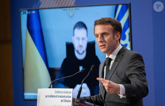 Le président français Emmanuel Macron prononce un discours pendant que le président ukrainien Volodymyr Zelensky écoute par liaison vidéo lors de la conférence bilatérale pour la résilience et la reconstruction de l'Ukraine au ministère de l'Économie à Paris, FRance, le 13 décembre 2022. © Jacques Witt/Pool/Bestimage 