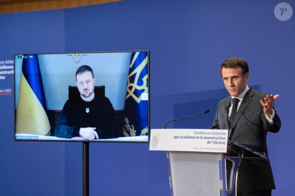 Le président français Emmanuel Macron prononce un discours pendant que le président ukrainien Volodymyr Zelensky écoute par liaison vidéo lors de la conférence bilatérale pour la résilience et la reconstruction de l'Ukraine au ministère de l'Économie à Paris, FRance, le 13 décembre 2022. © Jacques Witt/Pool/Bestimage 