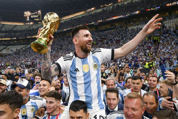 Joie MESSI Lionel (ARG) soulevant le trophee de la Coupe du Monde et porte en triomphe par ses coequipiers - Remise du trophée de la Coupe du Monde 2022 au Qatar (FIFA World Cup Qatar 2022) à l'équipe d'argentine après sa victoire contre la France en finale (3-3 - tab 2-4). Doha, le 18 décembre 2022. 