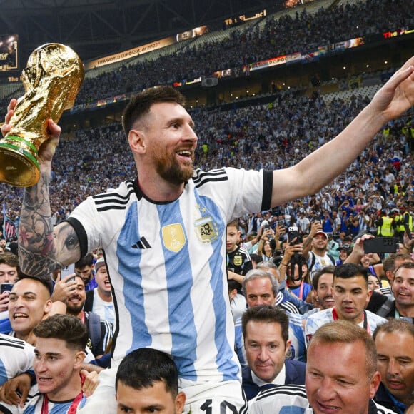 Lionel Messi (ARG) soulevant le trophee de la Coupe du Monde et porte en triomphe par ses coequipiers - Remise du trophée de la Coupe du Monde 2022 au Qatar (FIFA World Cup Qatar 2022) à l'équipe d'argentine après sa victoire contre la France en finale (3-3 - tab 2-4). Doha, le 18 décembre 2022. 