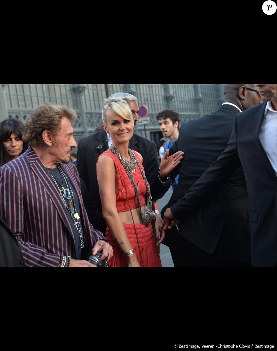 Johnny Hallyday et sa femme Laeticia Hallyday arrivent au défilé Saint Laurent Homme collection Printemps-Eté 2016 au Carreau du Temple lors de la Fashion Week à Paris, le 28 juin 2015.