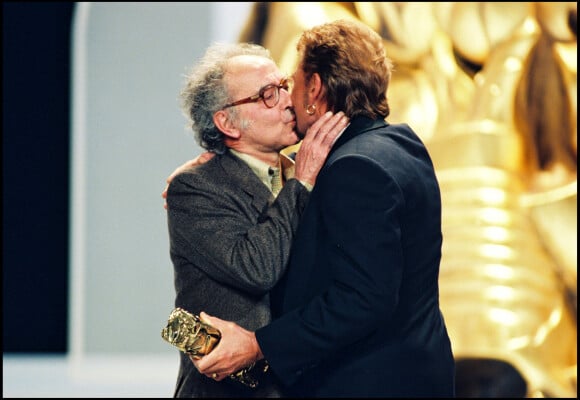 Il s'agit de Jean-Luc Godard qui l'a fait tourner dans Détective au côté de Johnny Hallyday
Johnny Hallyday remet un César à Jean-Luc Godard, en 1998