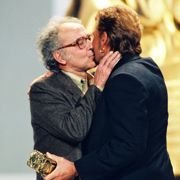 Il s'agit de Jean-Luc Godard qui l'a fait tourner dans Détective au côté de Johnny Hallyday
Johnny Hallyday remet un César à Jean-Luc Godard, en 1998