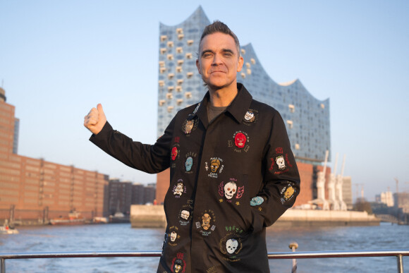 Si l'artiste n'a pas fait de déclaration sur une quelconque maladie, les fans s'inquiètent pour lui
Robbie Williams pose devant la Philharmonie de l'Elbe à Hambourg, le 14 novembre 2022.
