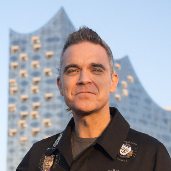 Si l'artiste n'a pas fait de déclaration sur une quelconque maladie, les fans s'inquiètent pour lui
Robbie Williams pose devant la Philharmonie de l'Elbe à Hambourg, le 14 novembre 2022.