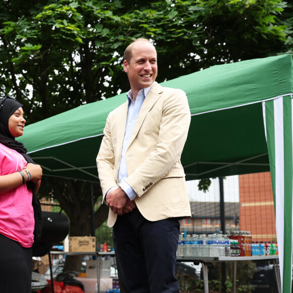 Le prince William, prince de Galles, salue les sympathisants lors d'une visite à l'association Reach Up Youth au centre Verdon Recreation à Sheffield, Royaume-Uni, le 27 juin 2023, pour mettre en lumière comment les sports de base peuvent connecter les jeunes à leurs communautés, en renforçant le soutien des pairs, dans le cadre de sa tournée du Royaume-Uni pour lancer un projet visant à mettre fin à l'itinérance. 