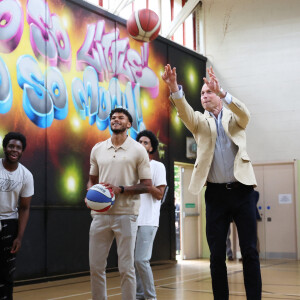 Le prince William, prince de Galles, salue les sympathisants lors d'une visite à l'association Reach Up Youth au centre Verdon Recreation à Sheffield, Royaume-Uni, le 27 juin 2023, pour mettre en lumière comment les sports de base peuvent connecter les jeunes à leurs communautés, en renforçant le soutien des pairs, dans le cadre de sa tournée du Royaume-Uni pour lancer un projet visant à mettre fin à l'itinérance. 