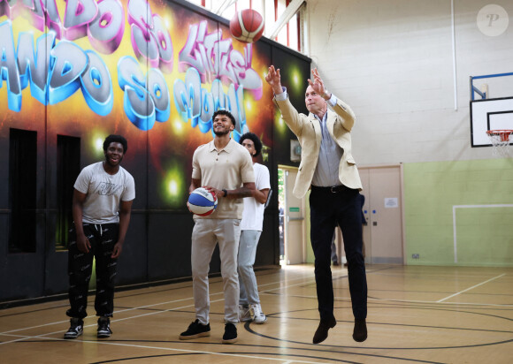 Le prince William, prince de Galles, salue les sympathisants lors d'une visite à l'association Reach Up Youth au centre Verdon Recreation à Sheffield, Royaume-Uni, le 27 juin 2023, pour mettre en lumière comment les sports de base peuvent connecter les jeunes à leurs communautés, en renforçant le soutien des pairs, dans le cadre de sa tournée du Royaume-Uni pour lancer un projet visant à mettre fin à l'itinérance. 