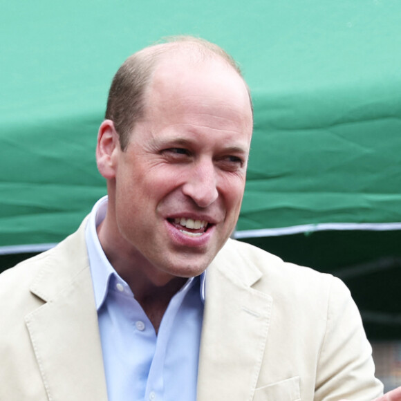 Le prince William, prince de Galles, salue les sympathisants lors d'une visite à l'association Reach Up Youth au centre Verdon Recreation à Sheffield, Royaume-Uni, le 27 juin 2023, pour mettre en lumière comment les sports de base peuvent connecter les jeunes à leurs communautés, en renforçant le soutien des pairs, dans le cadre de sa tournée du Royaume-Uni pour lancer un projet visant à mettre fin à l'itinérance. 