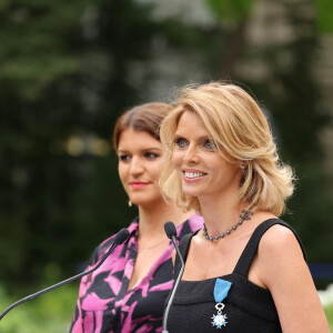 Exclusif - Sylvie Tellier et la secrétaire d'Etat, chargée de l'Économie sociale et solidaire et de la Vie associative, Marlène Schiappa - La présidente de l'association "Les Bonnes Fées", l'ancienne directrice générale d'un concours national de beauté et Miss France 2022, Sylvie Tellier décorée des l'insignes de chevalier de l'ordre national du Mérite par la secrétaire d'Etat, chargée de l'Économie sociale et solidaire et de la Vie associative dans les jardins de l'hôtel Matignon à Paris, France, le 26 juin 2023. C'est son investissement dans le milieu associatif qui vaut à l'ancienne directrice de miss France, cette distinction. Sylvie Tellier est co-fondatrice, avec plusieurs anciennes miss France, de l'association Les Bonnes fées, qui a pour objectif d'améliorer les conditions de vie des femmes à travers le financement de projets comme la création d'un lieu de détente dans les centres de cancérologie des hôpitaux ou des ateliers socio-esthétiques pour des femmes atteintes d'un cancer. © Dominique Jacovides/Bestimage