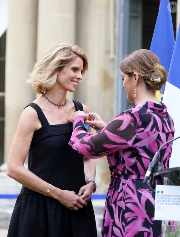 Exclusif - Sylvie Tellier et la secrétaire d'Etat, chargée de l'Économie sociale et solidaire et de la Vie associative, Marlène Schiappa - La présidente de l'association "Les Bonnes Fées", l'ancienne directrice générale d'un concours national de beauté et Miss France 2022, Sylvie Tellier décorée des l'insignes de chevalier de l'ordre national du Mérite par la secrétaire d'Etat, chargée de l'Économie sociale et solidaire et de la Vie associative dans les jardins de l'hôtel Matignon à Paris, France, le 26 juin 2023. C'est son investissement dans le milieu associatif qui vaut à l'ancienne directrice de miss France, cette distinction. Sylvie Tellier est co-fondatrice, avec plusieurs anciennes miss France, de l'association Les Bonnes fées, qui a pour objectif d'améliorer les conditions de vie des femmes à travers le financement de projets comme la création d'un lieu de détente dans les centres de cancérologie des hôpitaux ou des ateliers socio-esthétiques pour des femmes atteintes d'un cancer. © Dominique Jacovides/Bestimage