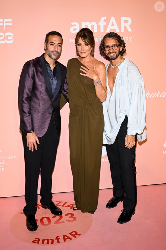 De nombreuses célébrités ont répondu à l'appel, dont Carla Bruni, somptueuse dans une robe kaki assortie de bijoux Chopard.
Mohammed Al Turki, Carla Bruni, Simone Marchetti au photocall de la soirée "amfAR" lors du 80ème Festival International du Film de Venise (Mostra), le 3 septembre 2023.