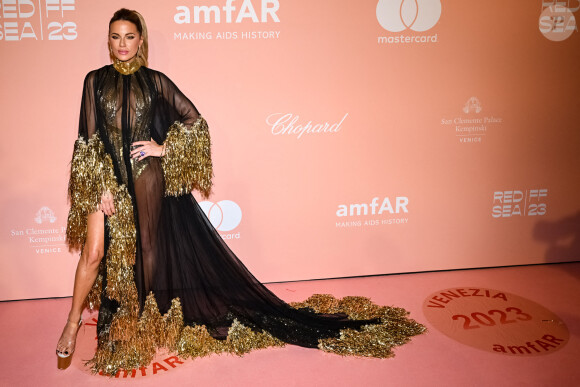 Kate Beckinsale avait fait appel au couturier libanais Georges Chakra pour l'habiller. Elle portait une sorte de body doré sous sa robe noire et transparente à franges dorées. 
Kate Backinsale au photocall de la soirée "amfAR" lors du 80ème Festival International du Film de Venise (Mostra), le 3 septembre 2023.