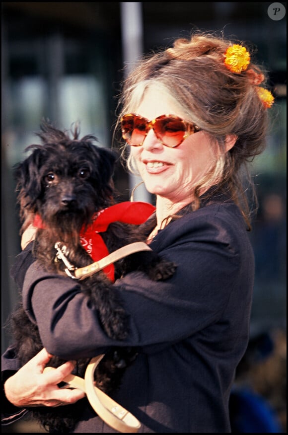 Brigitte Bardot avec dans les bras un chien.