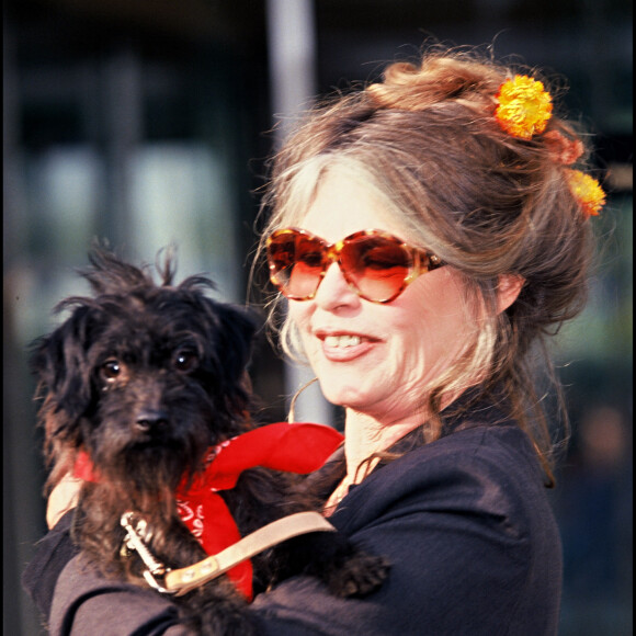 Brigitte Bardot avec dans les bras un chien.