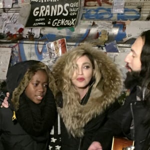 Exclusif - Madonna se recueille avec son fils David Banda sur la place de la République vers 1h00 du matin après son concert à l'AccorHotels Arena (Bercy) à Paris le 9 décembre 2015. Madonna accompagnée de son guitariste a improvisé une prestation en acoustique de Ghosttown, Imagine de John Lennon et son tube Like a Prayer en hommage aux victimes des attentats terroristes de Paris. Les quelques badauds, très chanceux et surpris de découvrir Madonna en plein milieu de Paris et en pleine nuit, ont repris en choeur ses chansons. Un très beau moment de communion qui à ému aux larmes l'artiste. 