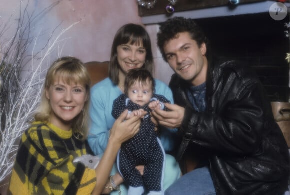 Rétro - Dorothée fête ses 70 ans le 14 juillet et ses 50 ans de carrière - Archives - No Web - En France, à Paris, Dorothée, dans un décor de Noël, en compagnie, d'Ariane Carletti de son mari Remy Sarrazin, chanteur des MUSCLES et de leur bébé Tristan en décembre 1989