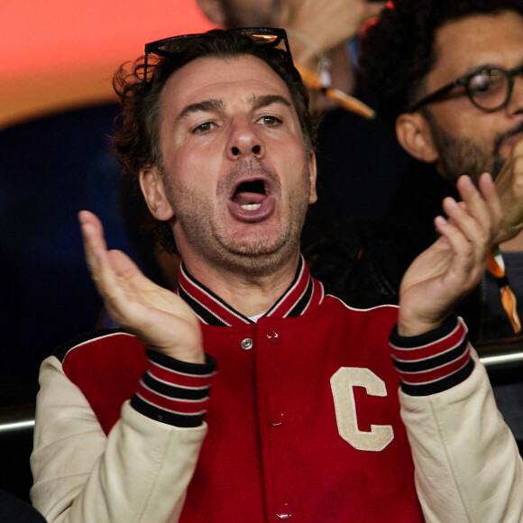 C'est donc l'occasion de s'intéresser à Michael Youn, 
Michaël Youn - People dans les tribunes du match de Ligue des champions entre le PSG et le Borussia Dortmund (2-0) au Parc des Princes à Paris le 19 septembre 2023. © Cyril Moreau/Bestimage